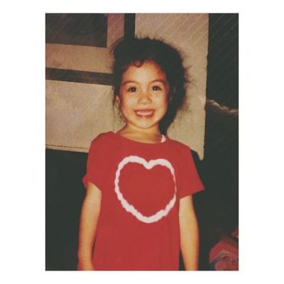 Childhood photo of  Meg DeLacy wearing a red tshirt